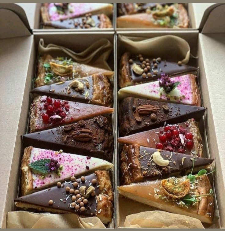 An open box holding a dozen slices of tart, each finished differently